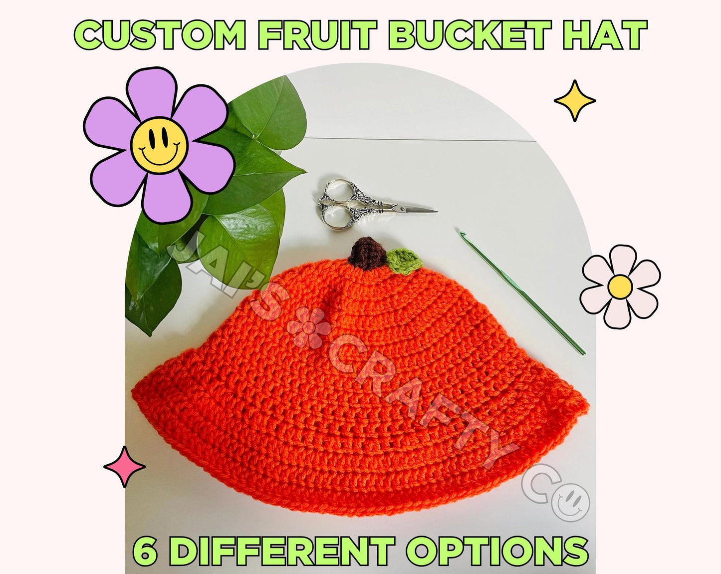 Green text frames the photo reading "Custom Fruit Bucket Hat, 6 different options." Centered is a handmade crochet bucket hat on a plain white background. The bucket hat is orange with a brown stem and a small green leaf resembling an orange. On the left is a houseplant, above is a pair of vintage silver scissors, and to the right is a green crochet hook. There are also retro Y2K inspired sparkles and smiley face flowers framing the photo giving a cutesy vibe.